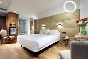 een slaapkamer met een groot wit bed en een woonkamer bij Hotel SB Glow Sup in Barcelona