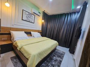 a bedroom with a bed and a black curtain at Genesis Grid Homes - Ibiza Edition in Lagos