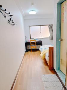 a bedroom with a desk and a bed and a window at ひまわりHotel in Nagasaki