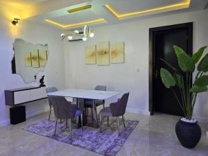 a dining room with a table and chairs and a plant at Genesis Grid Homes - Ibiza Edition in Lagos