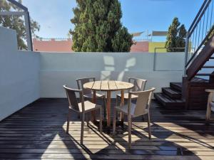 a table and chairs on a patio with stairs at De Waterkant Cottages in Cape Town