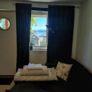 a bedroom with a window with blue curtains at Apartment near center / free P in Ålesund