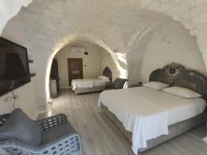 1 dormitorio con 2 camas y TV de pantalla plana en Aslan Guest House, en Sanlıurfa