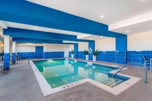 a large swimming pool with blue tiles in a building at Best Western Plus Kindersley Hotel in Kindersley