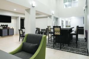 a living room with a couch and a table and chairs at La Quinta by Wyndham Fairfield - Napa Valley in Fairfield