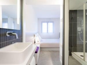 ペルピニャンにあるNovotel Suites Perpignan Centreのバスルーム(シンク、バスタブ付)、ベッド1台が備わります。