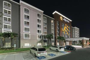 un hotel con due auto parcheggiate in un parcheggio di La Quinta Inn & Suites by Wyndham San Antonio Downtown a San Antonio