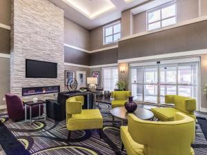 un soggiorno con sedie gialle e TV di La Quinta Inn & Suites by Wyndham San Antonio Downtown a San Antonio