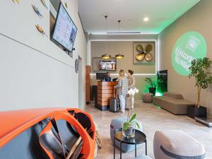 two people are standing in a living room at Ibis Styles Lisboa Centro Liberdade NE in Lisbon
