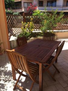 una mesa de madera y sillas en un patio en Case sul mare, en Palau