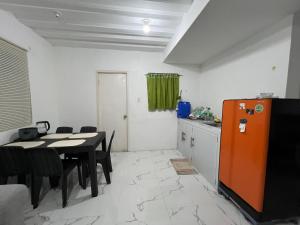 a kitchen and dining room with a table and a refrigerator at Affordable 2 storey transient house with free wifi in Camella Homes Koronadal in Carpenter