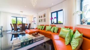 an orange couch with green pillows in a living room at Villa-Galeria-Verde-in-Betlem in Colonia de Sant Pere