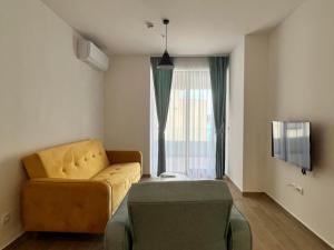 a living room with a yellow couch and a window at Rafailovici Beachfront Apartment 2 in Budva