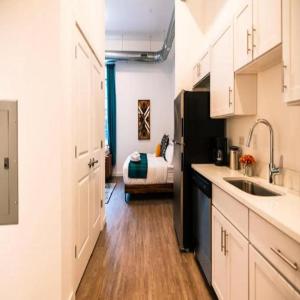 uma cozinha com armários brancos e um frigorífico preto em Pet Friendly North Shore Studio w/ Fitness Center em Pittsburgh