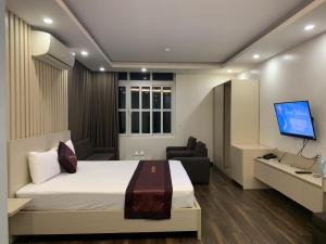 Habitación de hotel con cama y TV en Khách Sạn Tom’s, en Thái Nguyên