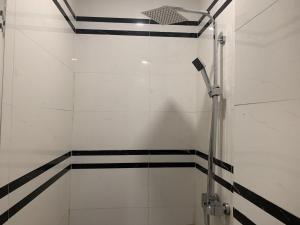 baño con ducha con rayas blancas y negras en Khách Sạn Tom’s, en Thái Nguyên