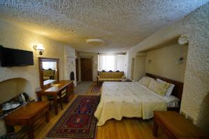 ein Schlafzimmer mit einem großen Bett und einem Sofa in der Unterkunft Vezir Cave Suites in Goreme