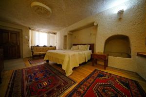 1 dormitorio con 1 cama en una habitación con alfombra en Vezir Cave Suites en Göreme