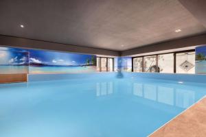 una piscina in una casa con illuminazione blu di Wyndham Grand Tbilisi a Tbilisi City