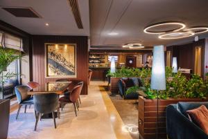 een restaurant met een tafel, stoelen en planten bij Wyndham Grand Tbilisi in Tbilisi City