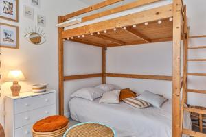 ein Schlafzimmer mit einem Etagenbett mit einer Leiter in der Unterkunft LE SPOT -T2 à 100m de la grande plage in Saint-Gilles-Croix-de-Vie
