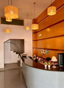 a lobby with a reception counter and lights at Hotel Piccadilly Sitges in Sitges