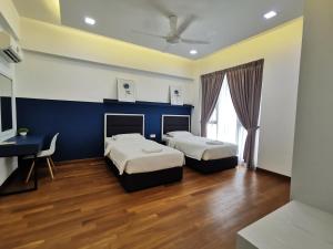 Jazz Service Suite Tanjung Tokong في Bagan Jermal: سريرين في غرفة ذات جدار أزرق