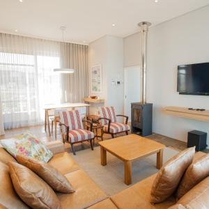 Bloubergstrand的住宿－Bokkombaai，客厅配有沙发、椅子和电视
