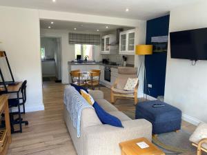 a living room with a couch and a kitchen at Osprey Cottage, Manton in Rutland in Manton