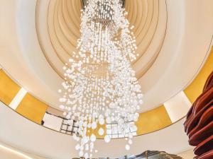 einen großen weißen Kronleuchter, der von einer Decke hängt in der Unterkunft Fairmont Doha in Doha