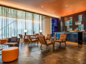 eine Lobby mit Stühlen, Tischen und einer Bar in der Unterkunft Fairmont Doha in Doha