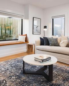 een woonkamer met een bank en een salontafel bij Luxury 4 Bedroom Beach House with Ocean Views and Smart Technology in Warrnambool