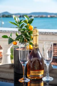 a bottle of wine and two glasses on a table at Guest House Maritimo in Sukošan