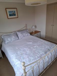 1 dormitorio con 1 cama con edredón azul en Blakeney Norfolk Bramble Lodge ***Self Catering*** en Blakeney