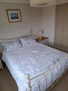 a bedroom with a bed with a blue comforter at Blakeney Norfolk Bramble Lodge ***Self Catering*** in Blakeney