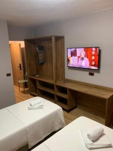 Habitación de hotel con 2 camas y TV de pantalla plana. en Hotel Dodona, en Sarandë