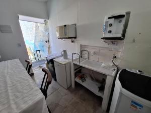 a small kitchen with a sink and a microwave at Hostel Jardim da Saúde in Sao Paulo