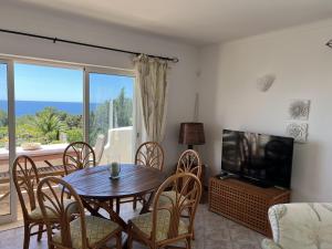 un soggiorno con tavolo, sedie e televisione di 233 Galo Verde Apartment, 2 Schlafzimmer a Benagil