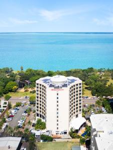 een uitzicht op een wit gebouw met de oceaan op de achtergrond bij Hilton Garden Inn Darwin in Darwin