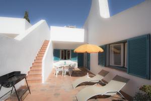 d'une terrasse avec une table, des chaises et un piano. dans l'établissement 433 Casa Pastrano, à Alvor