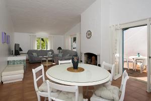 uma sala de estar com uma mesa branca e cadeiras em 433 Casa Pastrano em Alvor