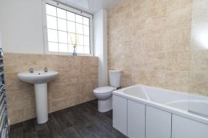 ein Badezimmer mit Toilette, Waschbecken und Badewanne in der Unterkunft Free Driveway Parking 3 Double Bedroom House, Ideal for long term contractor, etc stays, 4 miles 11 mins drive to Nissan, 20 mins drive to Sunderland Newcastle, Fast WIFI - see Dwellcome Home Ltd site for assurance in Jarrow