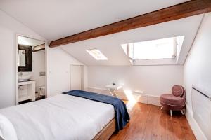 um quarto com uma cama, um lavatório e uma janela em The Almada Flats no Porto