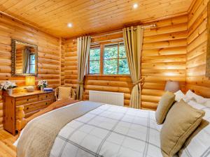 ein Schlafzimmer mit einem Bett in einem Blockhaus in der Unterkunft 3 Bed in Peebles LK15M in Walston