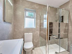 La salle de bains est pourvue de toilettes et d'une douche en verre. dans l'établissement 3 Bed in Peebles LK15M, à Walston