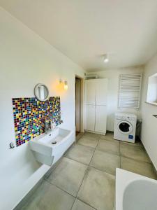 a bathroom with a sink and a washing machine at Design Apartaments in Ostrów Wielkopolski