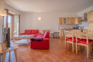 sala de estar con sofá rojo y cocina en LAirone Apt, en Pella