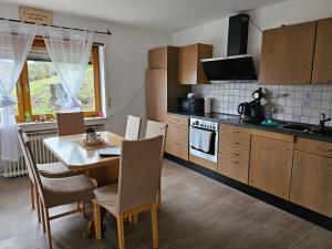 a kitchen with a wooden table and a table and chairs at T&G WirthHaus in Bad Rappenau