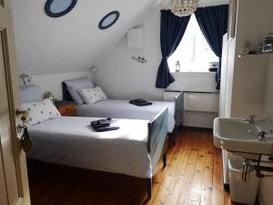 een kleine kamer met 2 bedden en een wastafel bij Elvebakk Bed & Breakfast in Reed