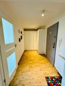 an empty hallway with a door and a wooden floor at Design Apartaments in Ostrów Wielkopolski